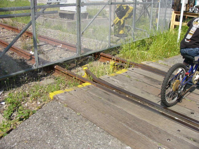 何も来ない踏切を渡る自転車の子供